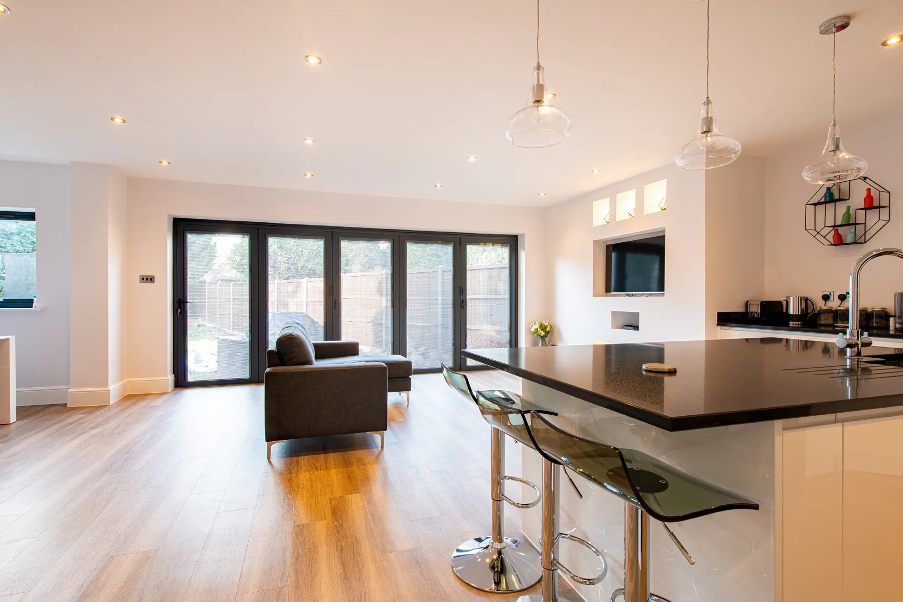 A kitchen with a bar and chairs in it.