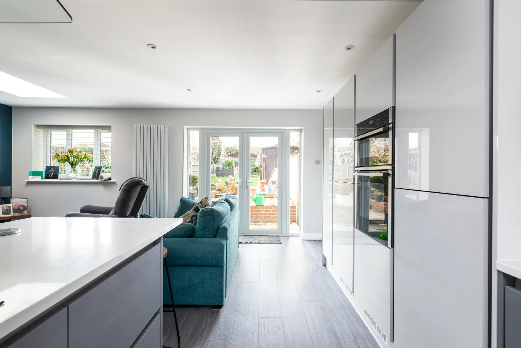 A kitchen with a blue couch and a white counter.